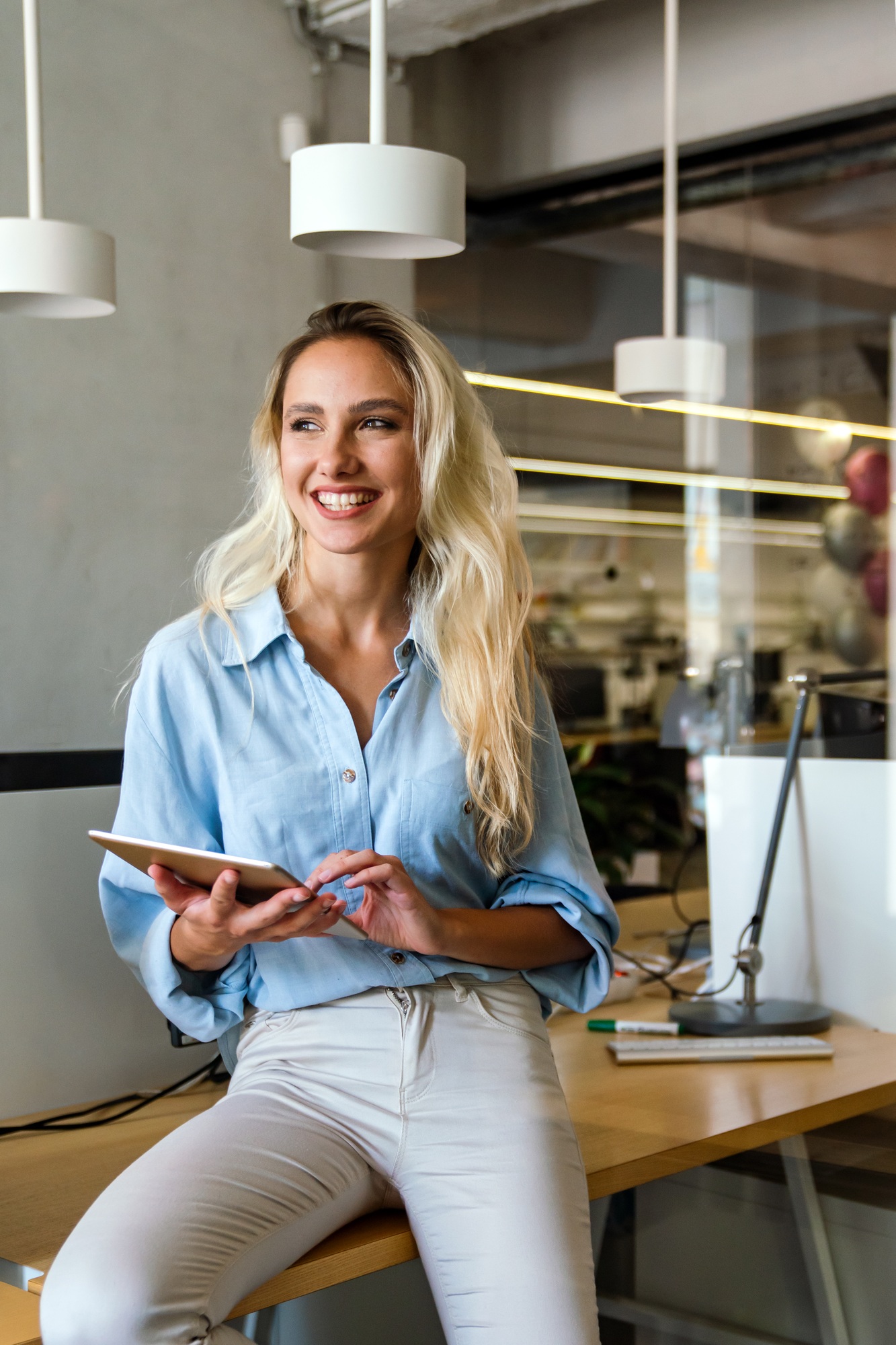 Portrait of an attractive young businesswoman smiling working on digital tablet in office